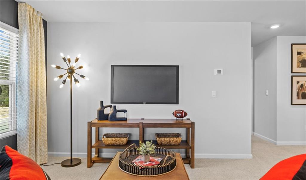 205 Storm Lane Hoschton, GA 30548 - Photo 35 of 51 a living room with furniture and a flat screen tv
