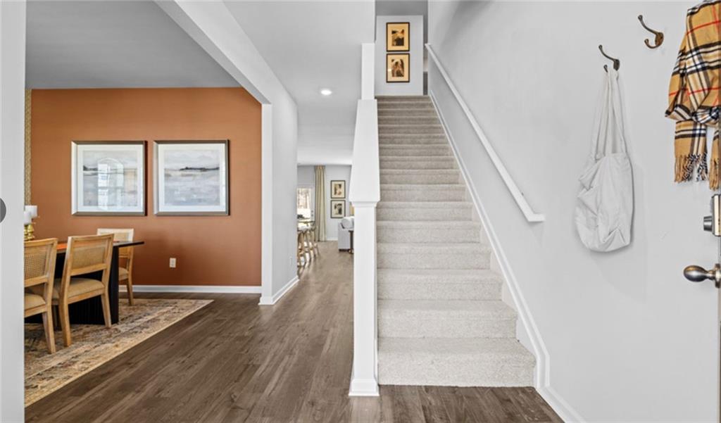 205 Storm Lane Hoschton, GA 30548 - Photo 50 of 51 a view of a hallway with wooden floor and staircase