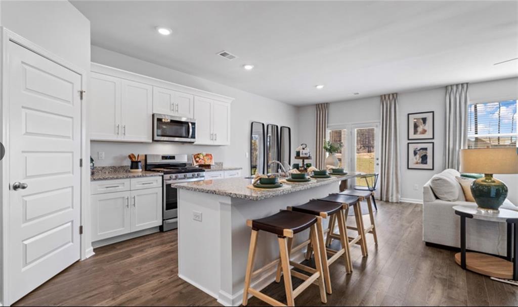 205 Storm Lane Hoschton, GA 30548 - Photo 9 of 51 a view of kitchen with microwave stove top oven and cabinets