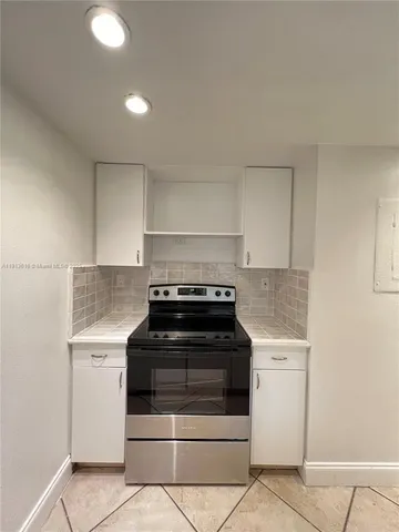 a kitchen with granite countertop white cabinets and white appliances
