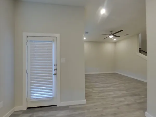 an empty room with a ceiling fan and window
