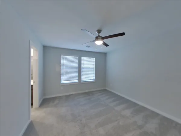 an empty room with a window and a fan