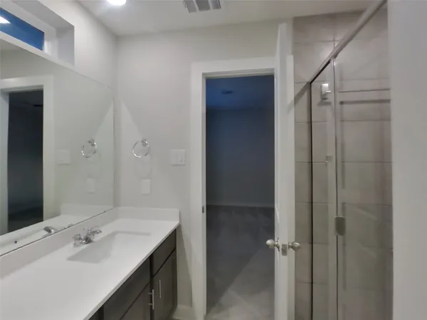 a bathroom with a shower sink and mirror