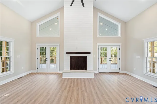 a large kitchen with stainless steel appliances a large counter top a wooden floor and a window