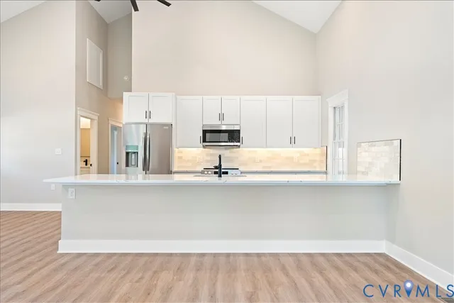 a kitchen with stainless steel appliances a refrigerator and a stove top oven