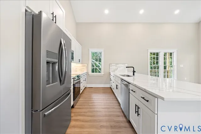 a view of cabinets a sink and dishwasher with wooden floor