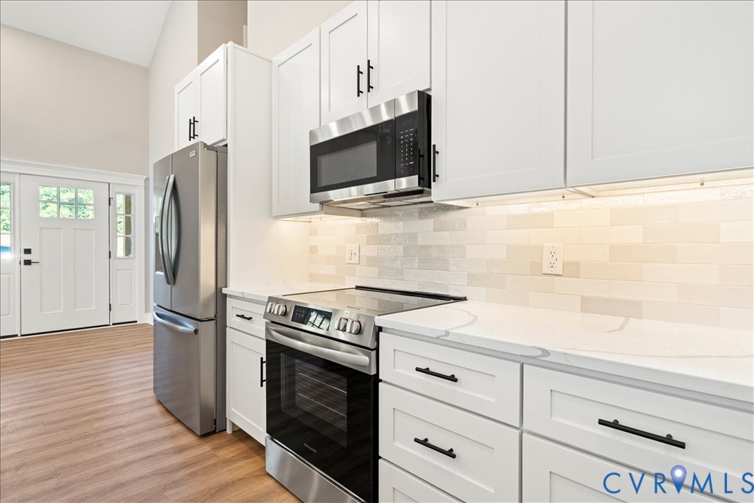 7 Trices Lake Road Columbia, VA 23038 - Photo 31 of 44 a kitchen with stainless steel appliances white cabinets and wooden floor