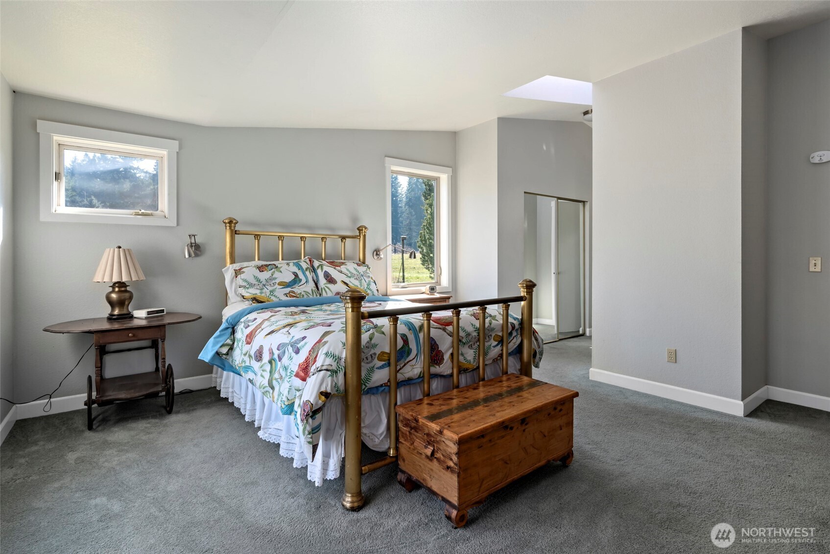 5477 Wilkinson Road Langley, WA 98260 - Photo 22 of 40 a bed sitting in a bedroom next to a window and a lamp