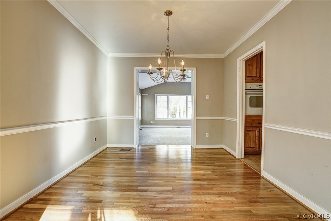 1519 Village Grove Road Henrico, VA 23238 - Photo 6 of 36 a view of a room with wooden floor chandeliers and kitchen view