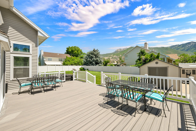 4792 Glasmann Way South Ogden, UT 84403 - Photo 27 of 70 Spacious composite deck with white railing overlooking a fenced backyard featuring a manicured lawn and mature trees