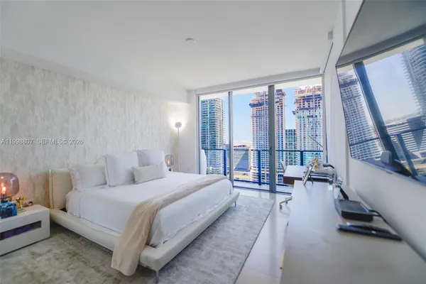 a large bedroom with bed and glass door