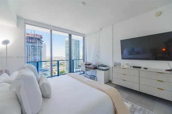 a bedroom with a bed and a flat screen tv