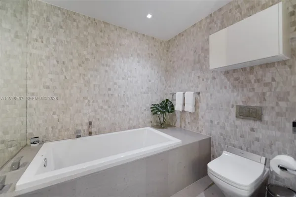 a white bath tub sitting next to a white toilet