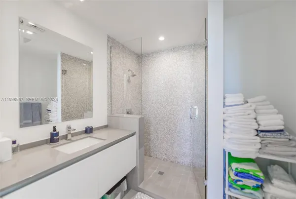 a bathroom with a granite countertop tub sink and mirror