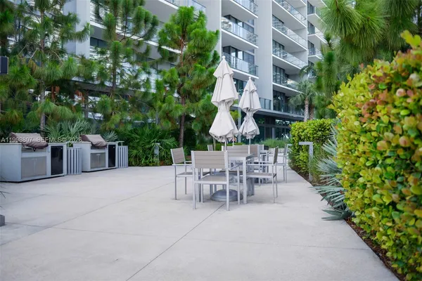 a view of a patio with a table and chairs and potted plants