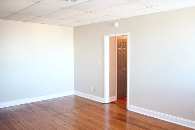 a view of an empty room with wooden floor