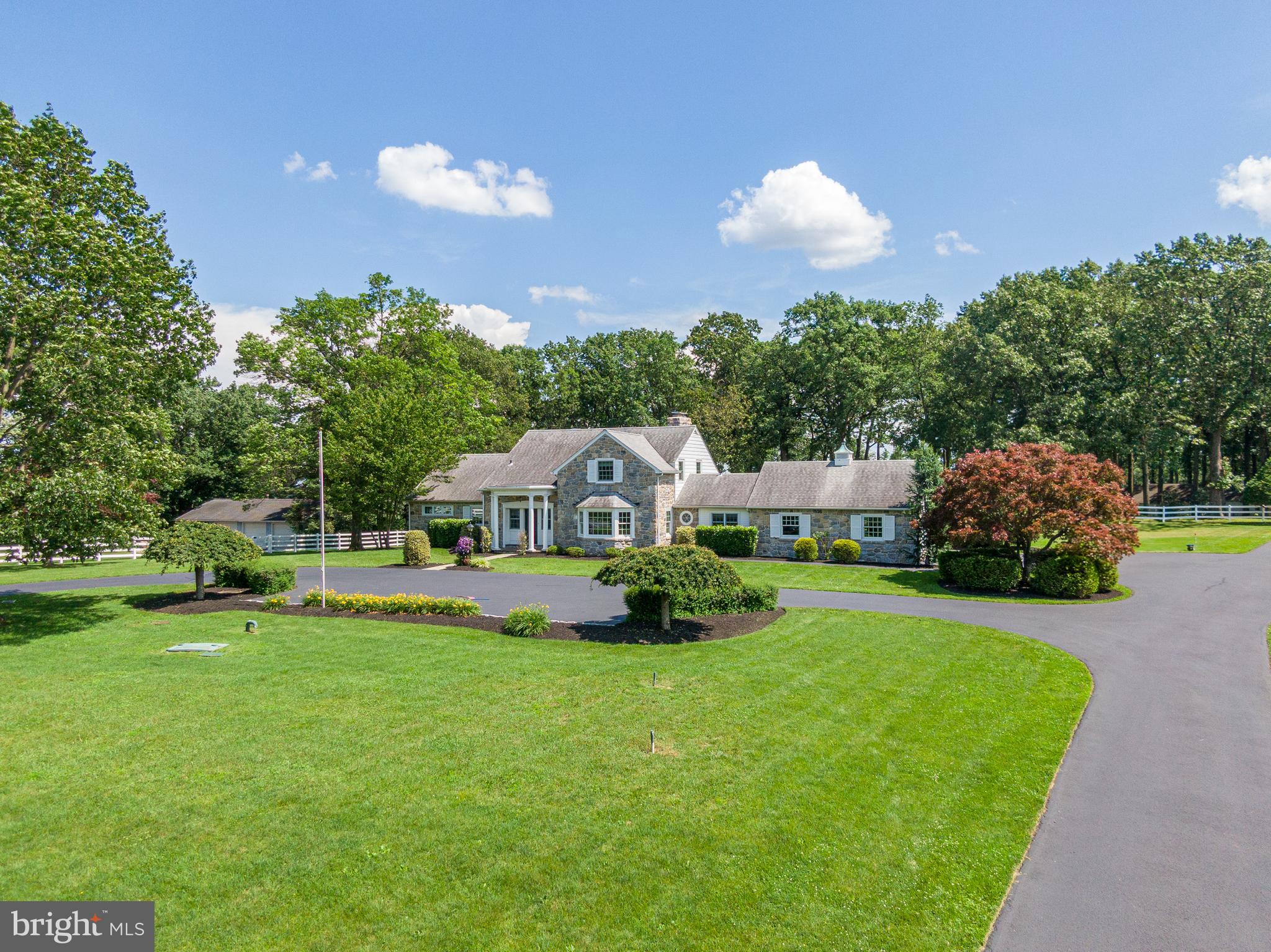 a view of a house with a big yard and large trees