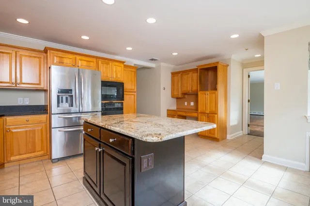 a kitchen with stainless steel appliances granite countertop a sink and a refrigerator