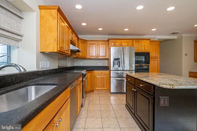 a kitchen with stainless steel appliances granite countertop a sink counter space cabinets and a large window
