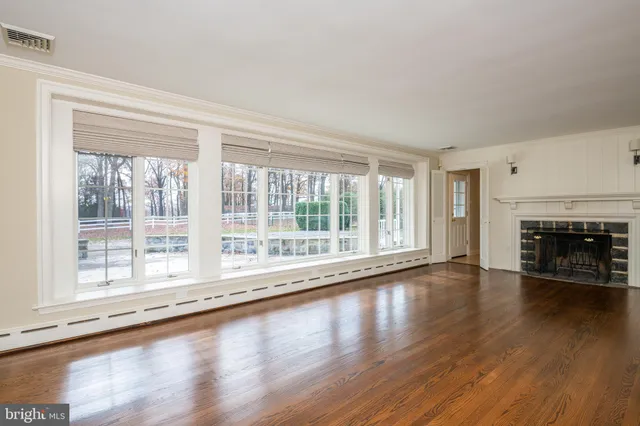 a view of empty room with wooden floor and fireplace