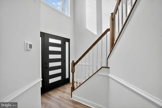 a view of staircase with wooden floor and white walls