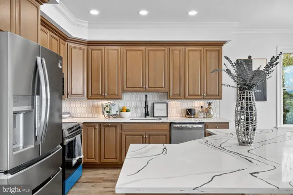 a kitchen with stainless steel appliances granite countertop a refrigerator sink and cabinets