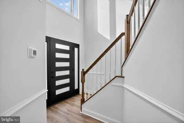 a view of staircase with wooden floor and white walls
