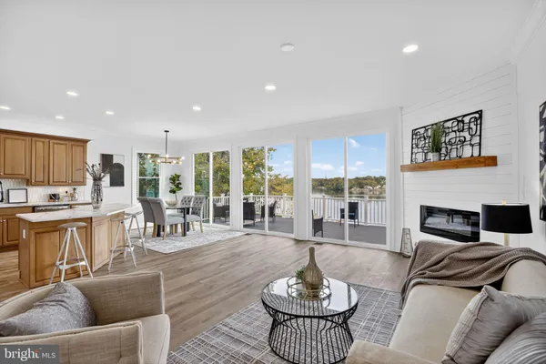 a living room with furniture kitchen view and large windows