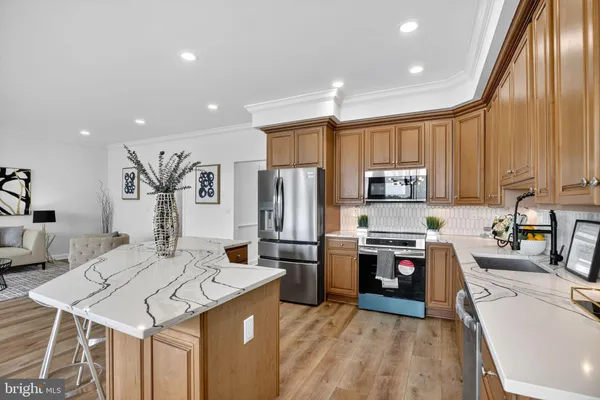 a kitchen with stainless steel appliances kitchen island granite countertop a sink refrigerator and cabinets