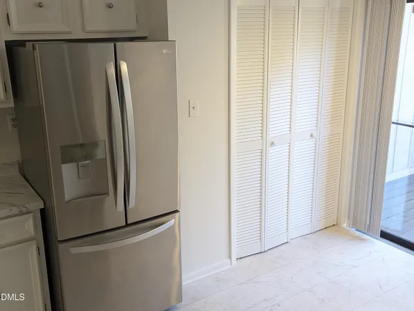 a view of kitchen with stainless steel appliances wooden floor and window