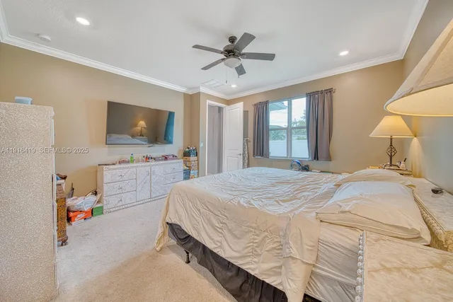 a spacious bedroom with a bed and a flat screen tv