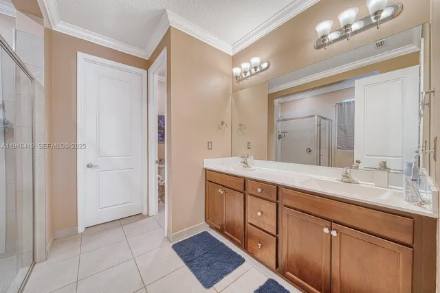 a spacious bathroom with a double vanity sink a mirror and a shower