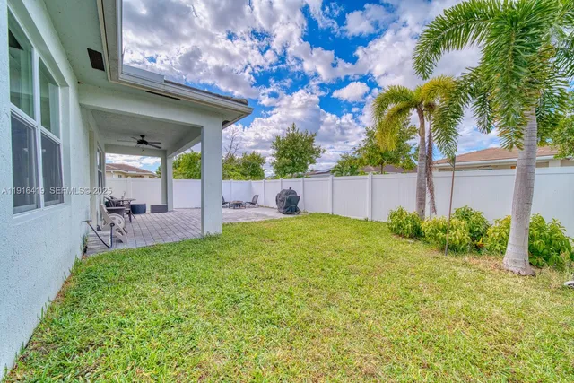 a view of a house with backyard and a tree