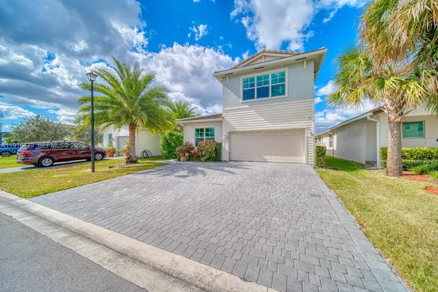 a front view of a house with a yard and a garage