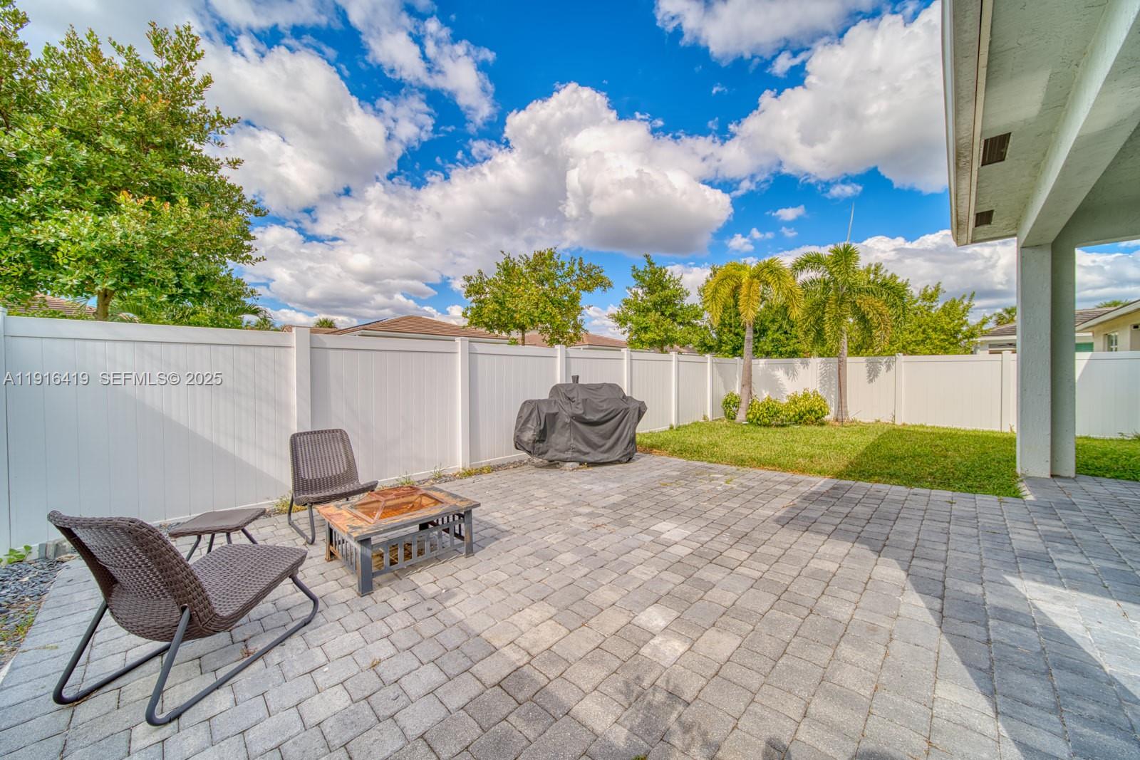 4147 Rosa Drive Deerfield Beach, FL 33064 - Photo 32 of 40 a backyard of a house with table and chairs