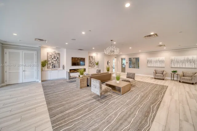 a living room with furniture a flat screen tv and kitchen view