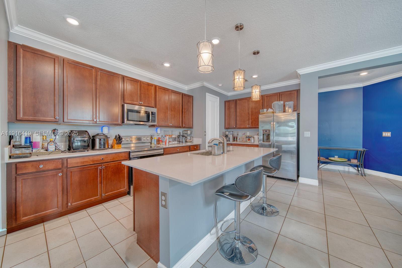 4147 Rosa Drive Deerfield Beach, FL 33064 - Photo 7 of 40 a kitchen with stainless steel appliances granite countertop a sink and cabinets