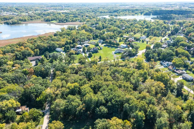 an aerial view of a houses with a lake and city view