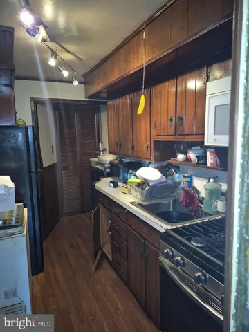 a kitchen with stainless steel appliances granite countertop a stove a refrigerator and a wooden cabinets