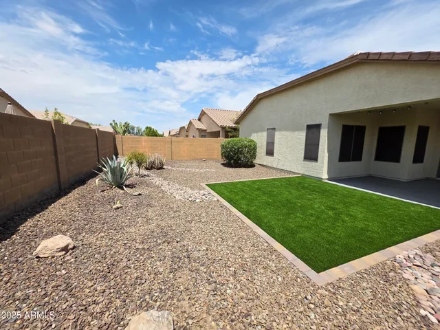 a front view of a house with a yard and potted plants