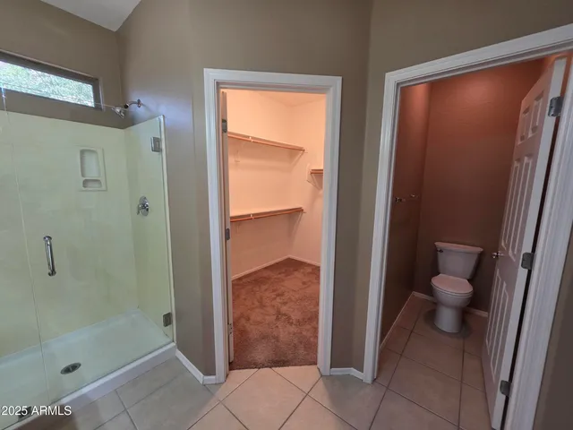 a bathroom with a granite countertop shower and a toilet