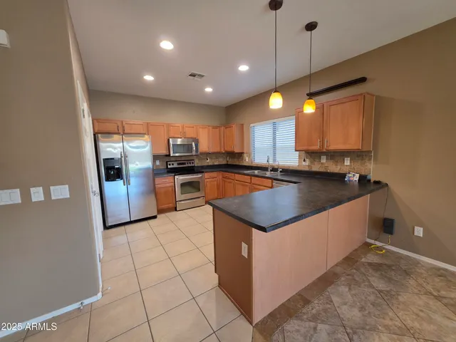 a kitchen with stainless steel appliances granite countertop a sink counter space cabinets and a window