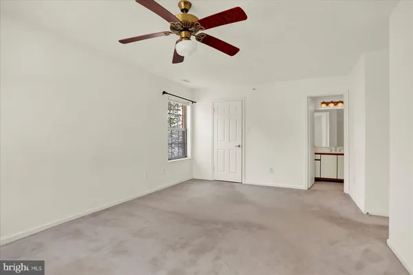 an empty room with chandelier fan