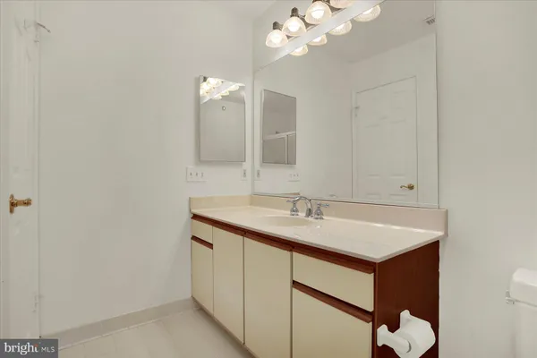 a bathroom with a sink a light fixture and a mirror