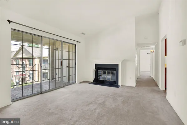 a view of an empty room with a fireplace and a window
