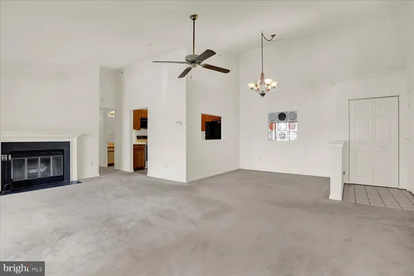 a view of empty room with fireplace and ceiling fan