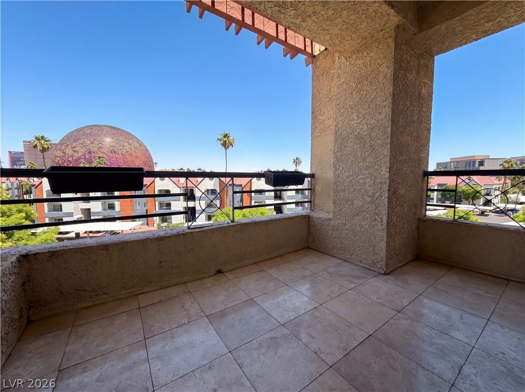 230 East Flamingo Road, Unit 320 Las Vegas, NV 89169 - Photo 13 of 19 City views and a clear sky from this tiled balcony, perfect for outdoor relaxation.