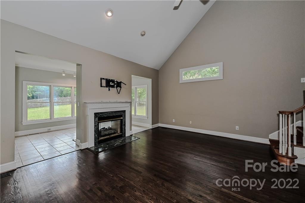 9528 Millen Drive Harrisburg, NC 28075 - Photo 19 of 48 a view of an empty room with wooden floor fireplace and a window