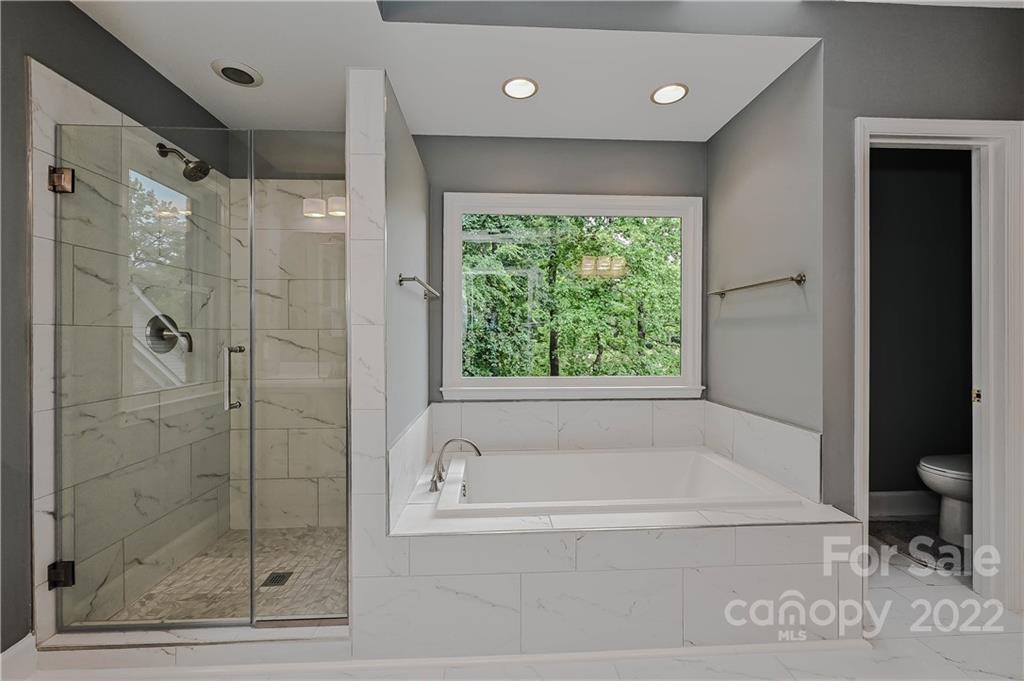 9528 Millen Drive Harrisburg, NC 28075 - Photo 33 of 48 a bathroom with a bathtub and a shower