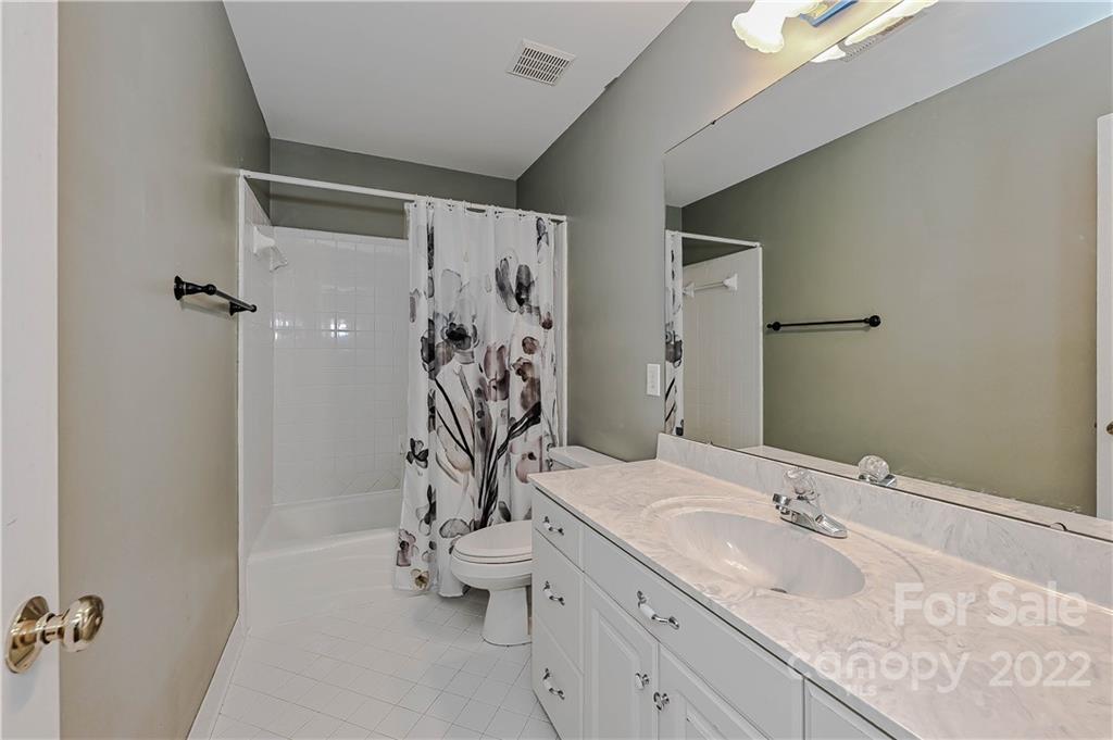 9528 Millen Drive Harrisburg, NC 28075 - Photo 40 of 48 a bathroom with a granite countertop sink a toilet and a shower